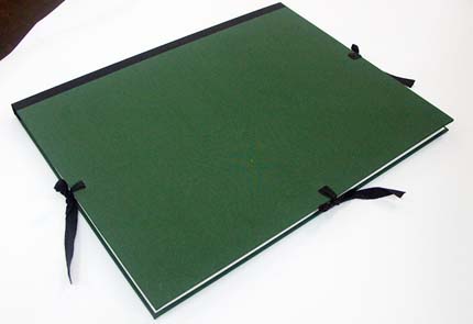 Carpeta amb llom de paper negre i folrada en tela verda; cintes de cotó negre i l'interior amb pestanyes de Paper Barrera.